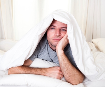 Tired man with sheets over head