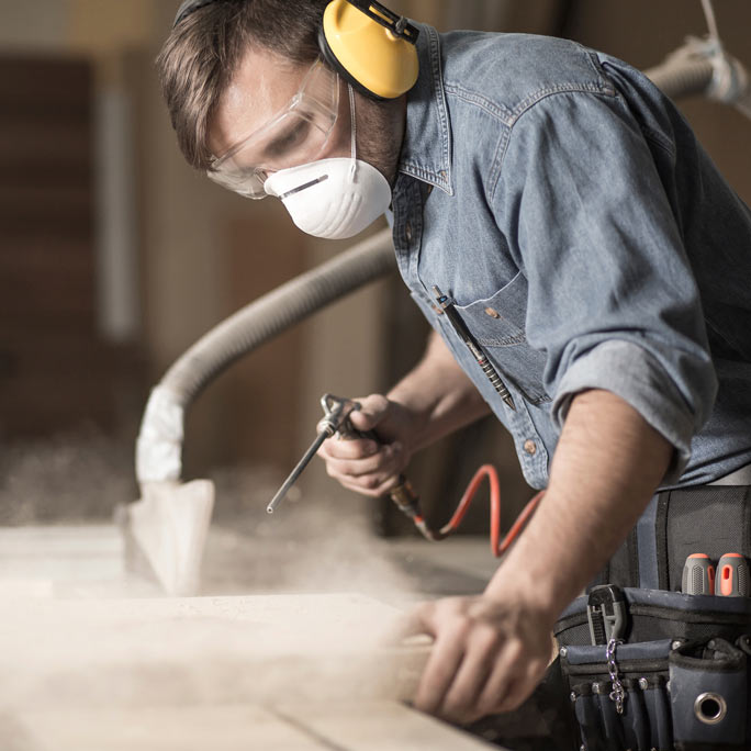 Woodworker dust off wood slab.