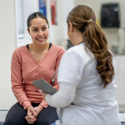 Young woman talking to her doctor at appointment.